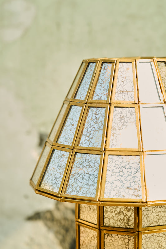 Decorative lamp with gold frame and textured glass on a neutral background