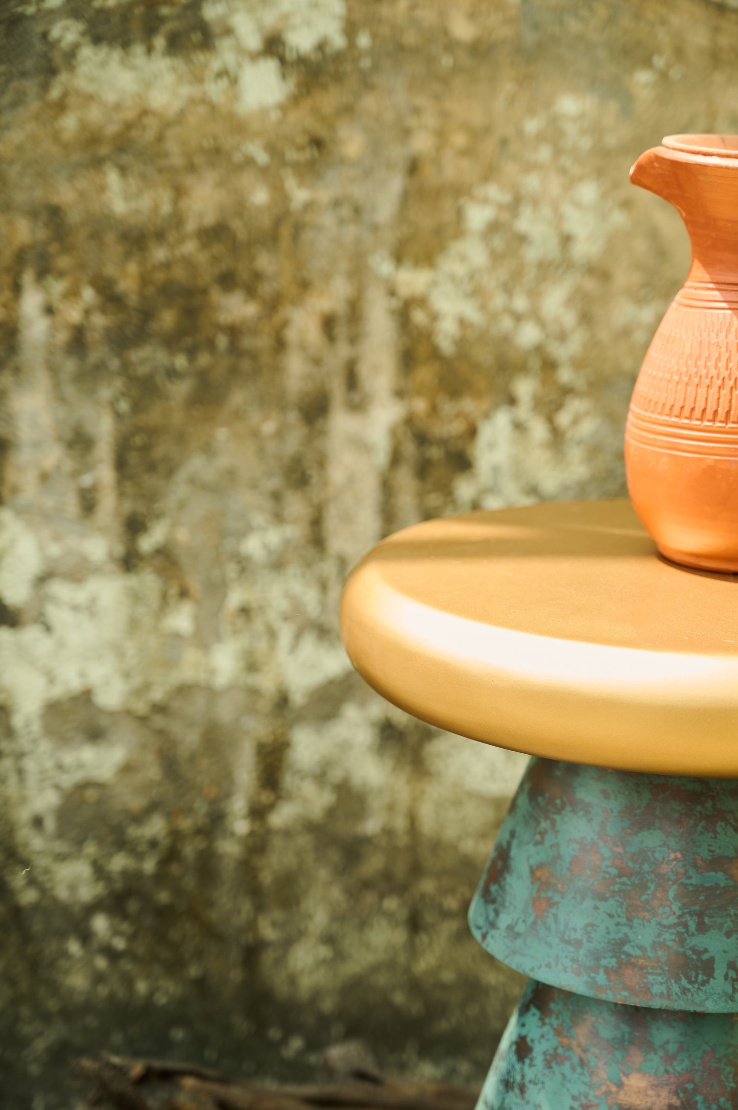 Terracotta vase on a textured surface with a blurred background