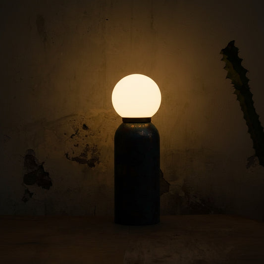 Light bulb inside a dark bottle against a textured wall