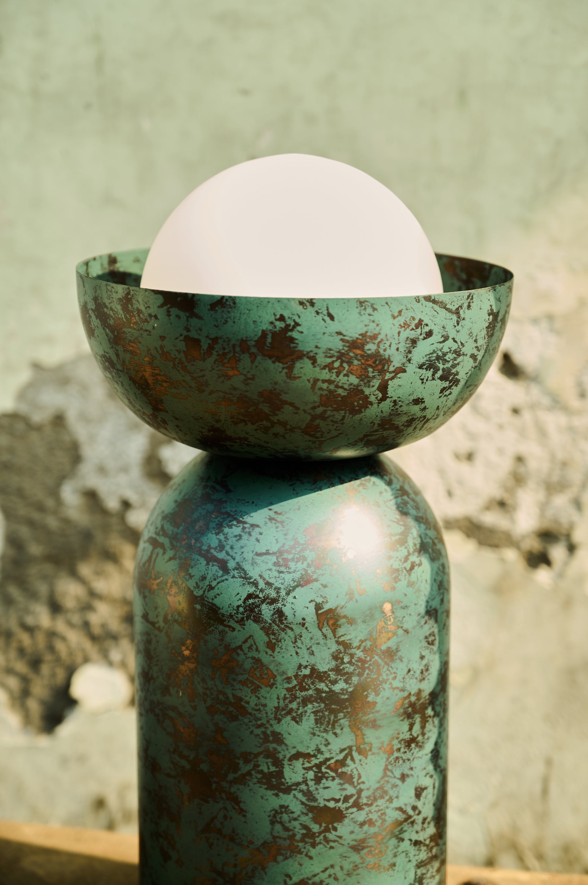 Decorative object with a white sphere on a textured green surface