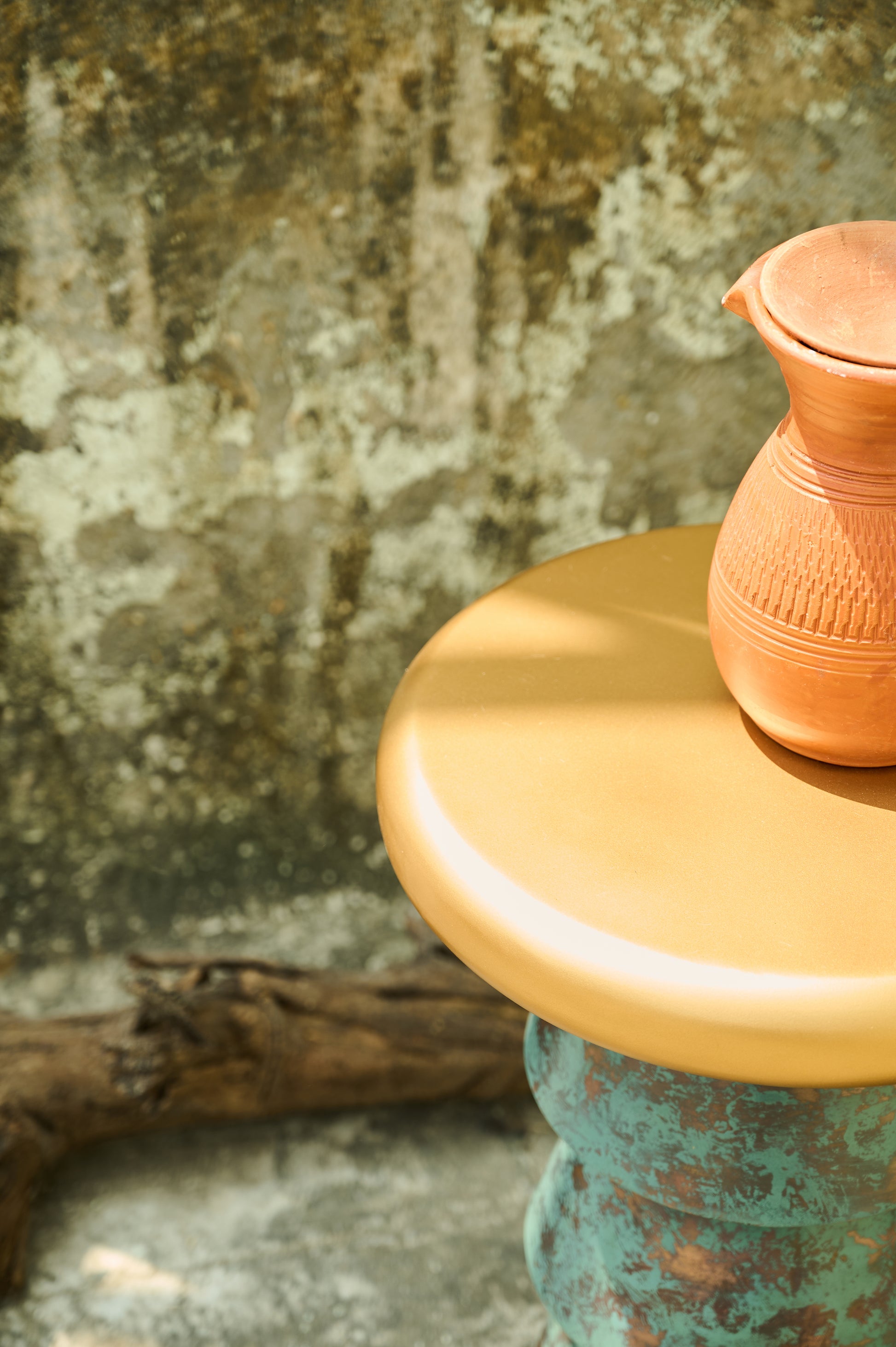 Ceramic pitcher on a textured surface with a rustic background