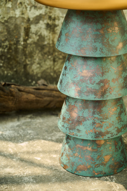 Stacked metal bowls with a textured surface on a stone surface.