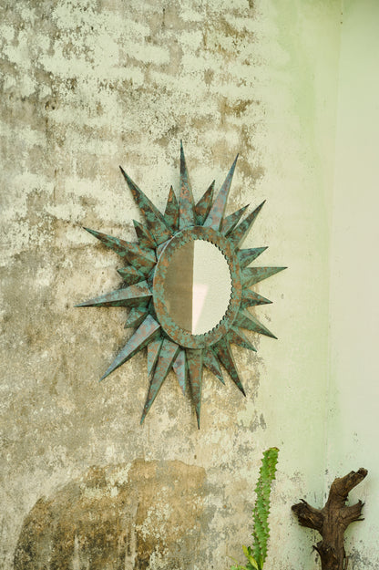 Decorative sun-shaped mirror on a textured wall