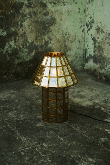 Decorative lamp with a textured shade on a dark surface