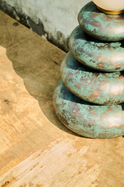 Stack of greenish-brown stones on a stone surface