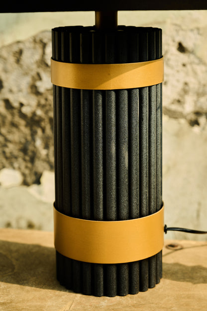 Black and yellow cylindrical object on a textured surface with a blurred natural background
