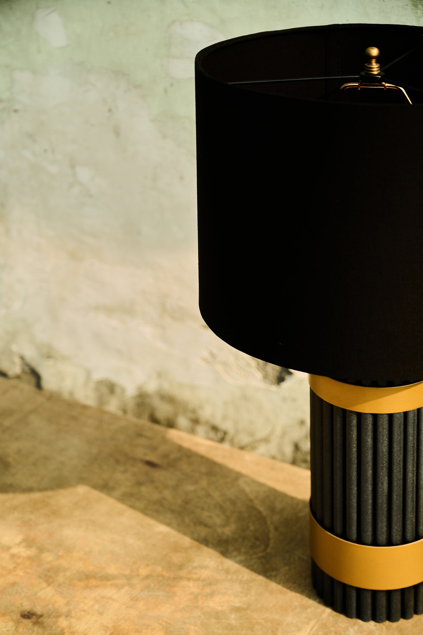 Black lamp with yellow base on a textured surface