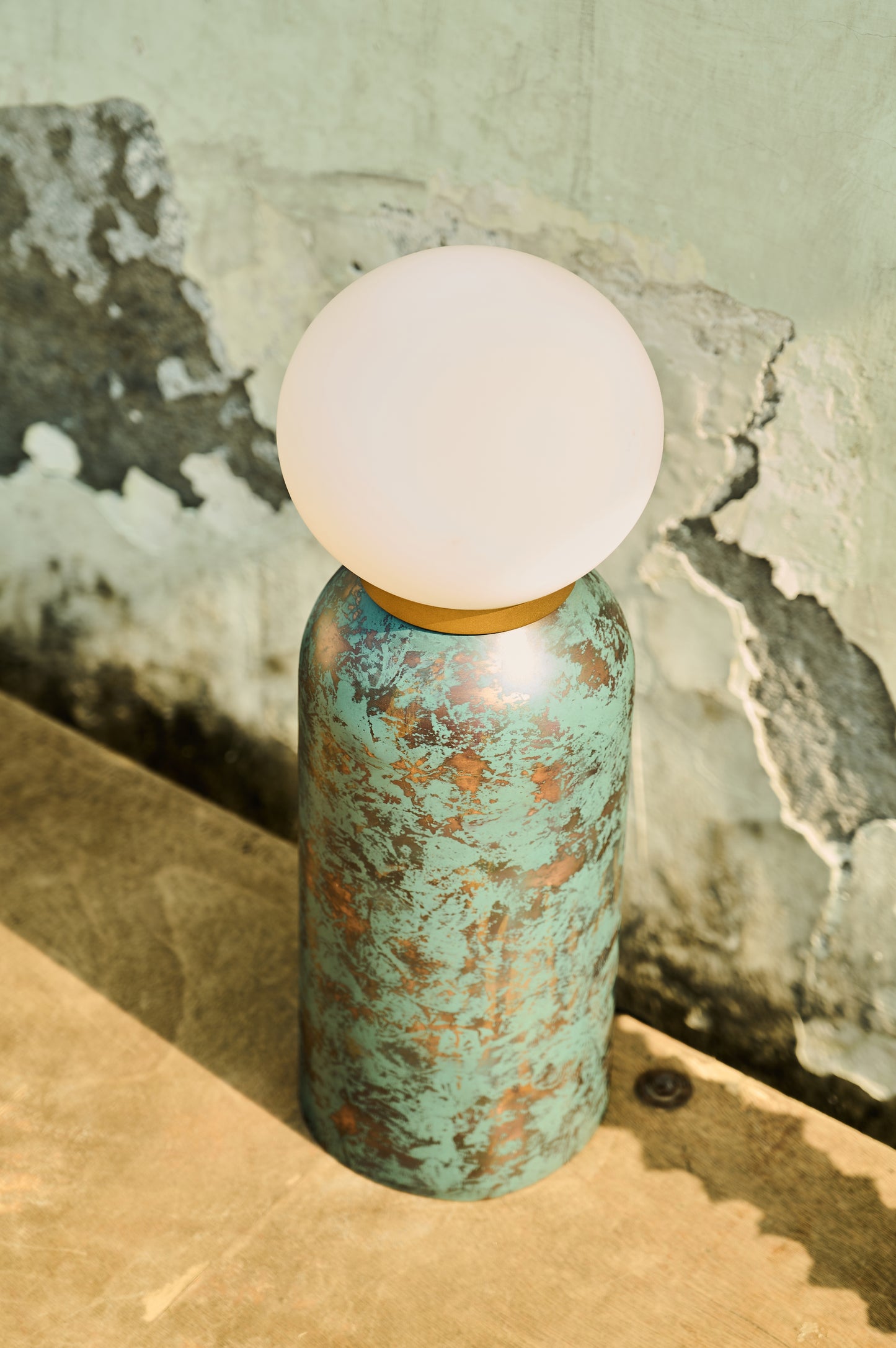 Decorative bottle with a white spherical top on a textured surface