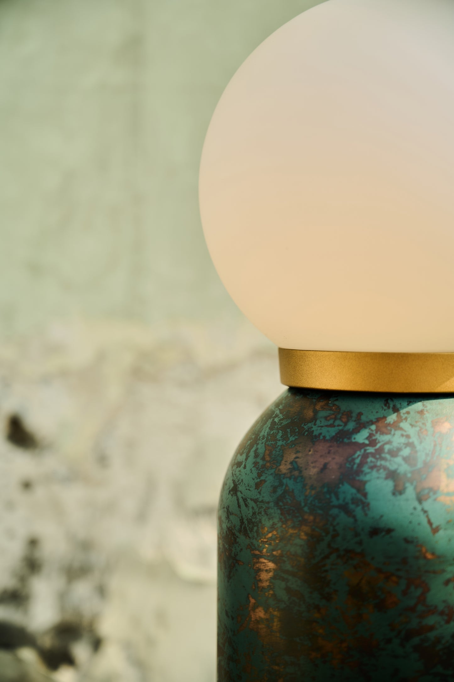 Close-up of a textured green bottle with a white cap on a blurred natural background