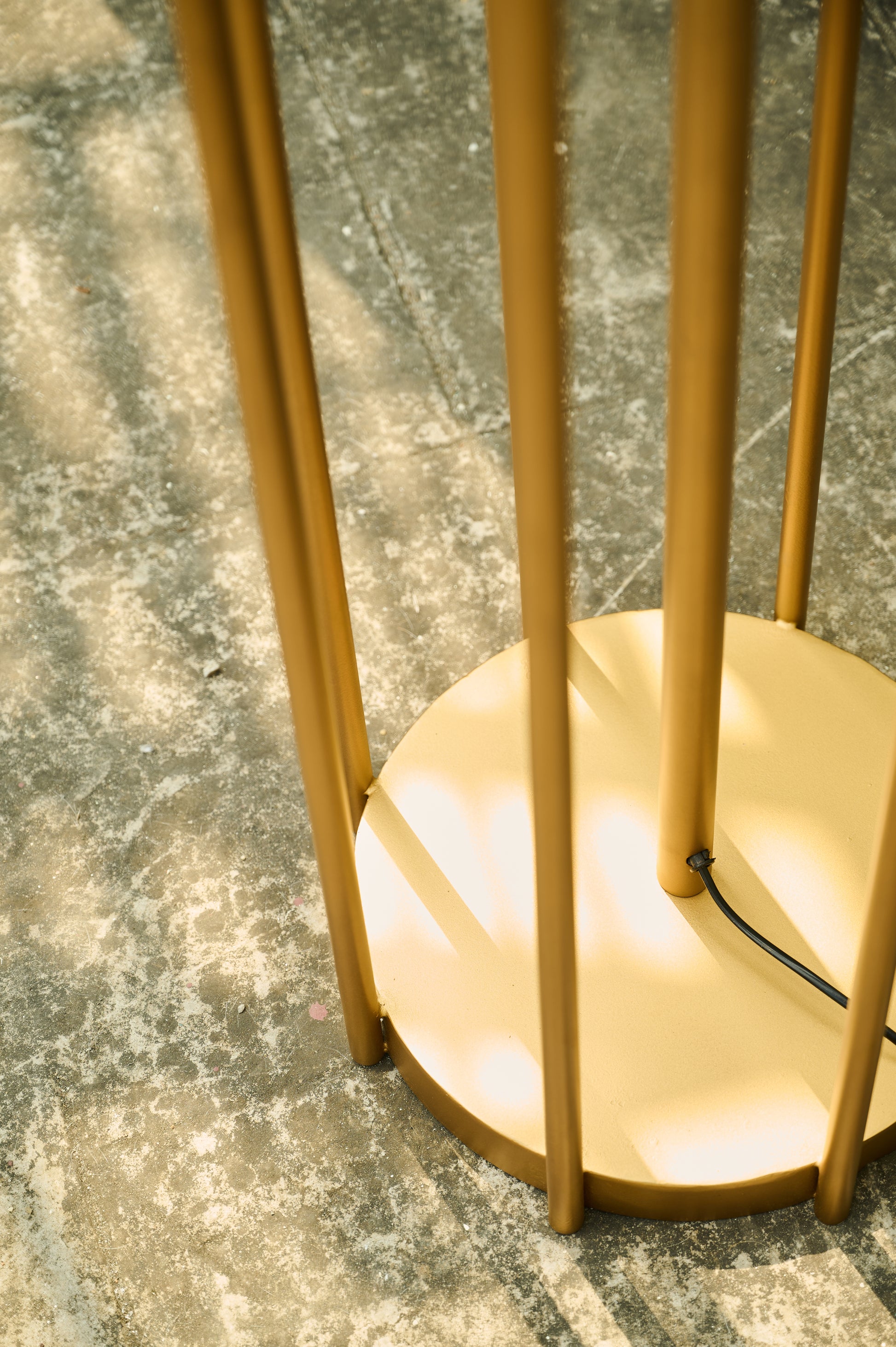 Gold floor lamp on a textured gray surface