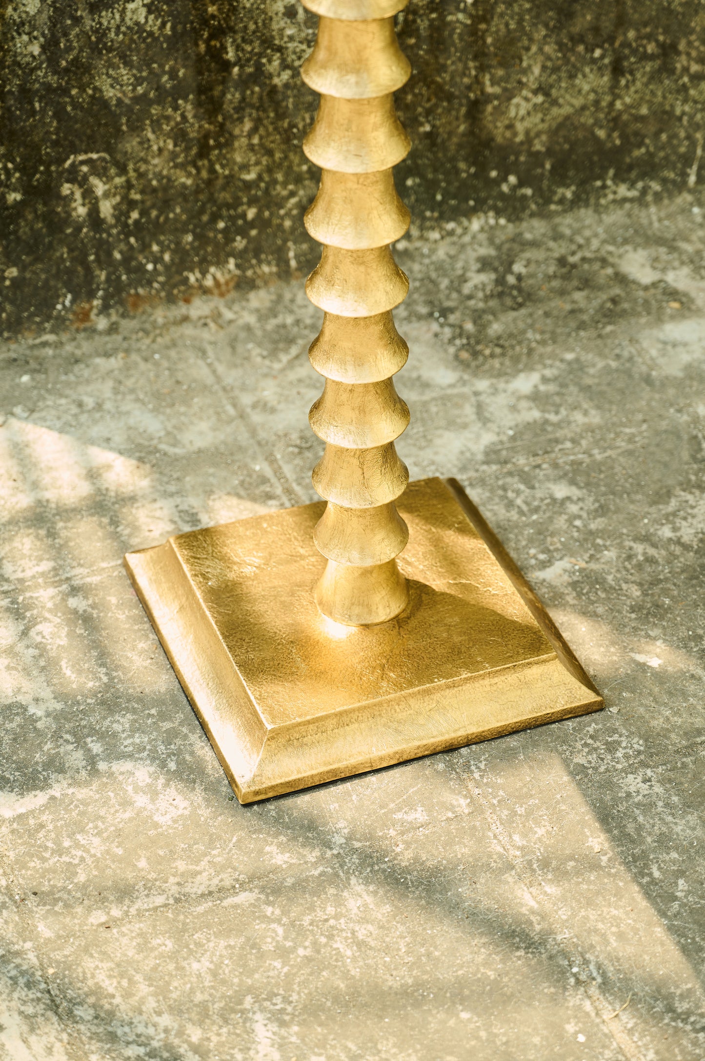 Gold candlestick on a textured stone surface