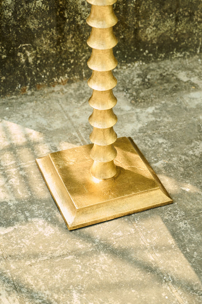 Gold candlestick on a textured stone surface