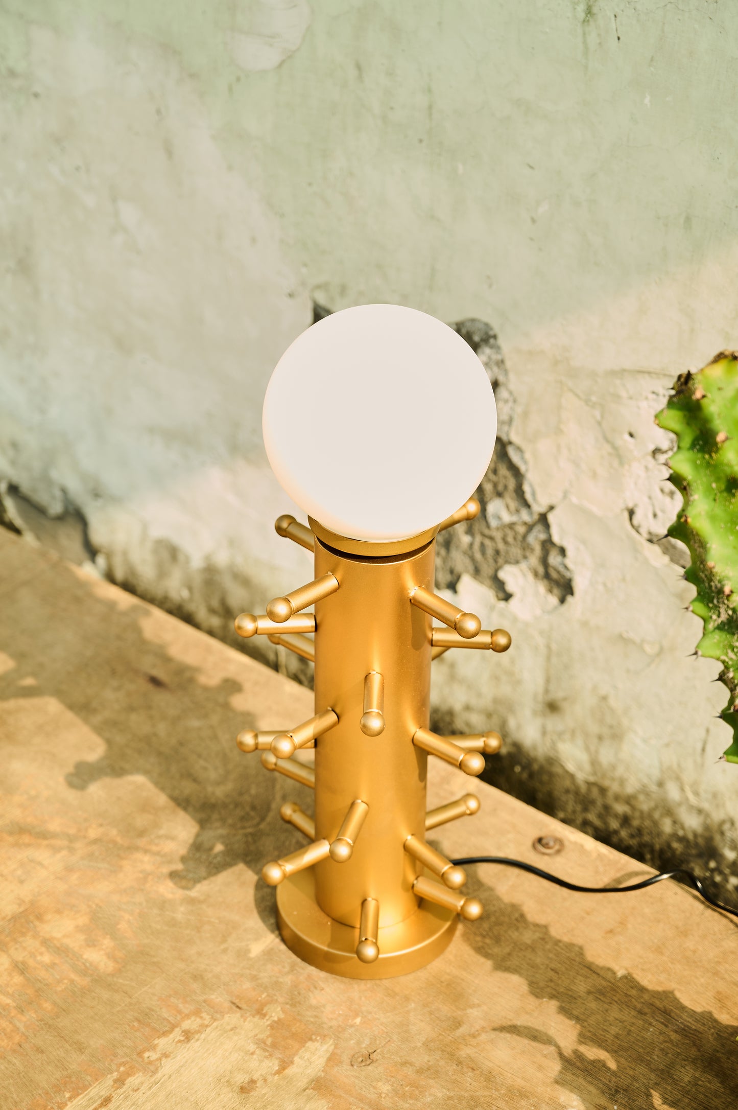 Gold lamp with a white bulb on a concrete surface