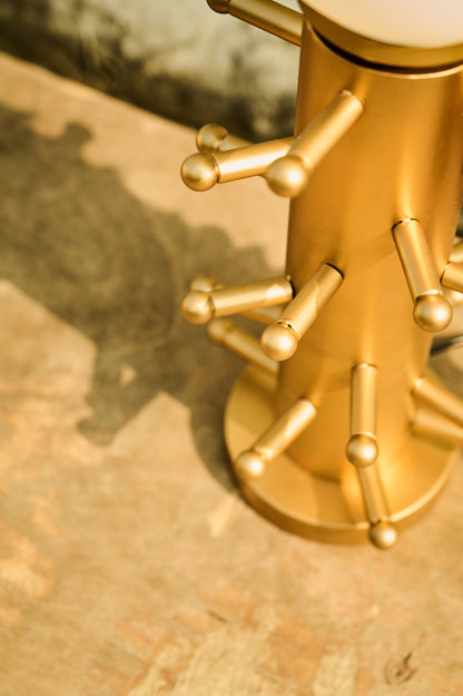 Gold tree-shaped decorative object on a textured surface