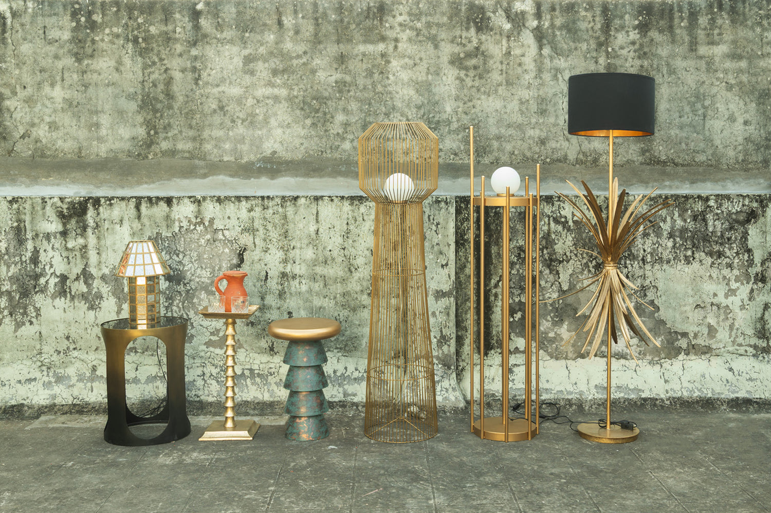 Collection of various lamps and decorative items against a textured wall.